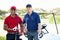 The best way to network. Portrait of two men standing on a golf course in front of a cart.