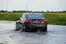 Bethany Beach, Delaware, U.S - October 1, 2020 - A black Chevy Malibu sedan passing the flooded road