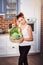 Beuatiful girl holding basket of fresh vegetables on modern scandinavian style kitchen background