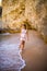 Beutiful latin mexican girl tourist walking on beach with rocks