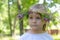 Beutiful little girl with handmade wreath on her head. Close-up