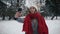 Beutiful Young Girl in the snowy forest makes a selfie. Slow motion. Portrait of stylish young beautiful girl in a