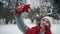 Beutiful Young Girl in the snowy forest makes a selfie. Slow motion. Portrait of stylish young beautiful girl in a