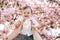 Beutifull little boy in his father hands laughs and smiles. Background of cherry blossom trees.