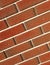 Beveled corner wall built red brick white seams. Textured brickwork