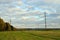 Beveled field in autumn, power line supports, yellow green forest, Kostroma region, Russia