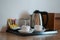 Beverage set with coffee cup, kettle, glasses, tea, coffee, sugar in hotel room