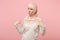 Bewildered confused arabian muslim woman in hijab light clothes posing isolated on pink background. People religious