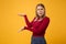 Bewildered perplexed young blonde woman girl in casual clothes posing isolated on yellow orange background studio