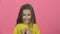 Bewitching child with smile is clapping her hands on pink background. Slow motion