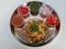Bhel chaat in a plate with onion,tomato, pomegranate, tamarind water and mint water as a background