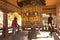 a Bhutanese man and tourists rotates a prayer wheel in a Buddhist pagoda