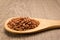 Bhutanese Red Rice seed. Grains in wooden spoon. Rustic.