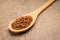 Bhutanese Red Rice seed. Spoon and grains over wooden table.