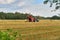 Biale, Poland - August 04, 2017: The tractor is working on the field. Stacks of straw and hay on the wheat field in Poland, late