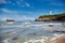 Biarritz, France. Sand beach Miramar Plage overlooking the white lighthouse - Phare de Biarritz on the Pointe Saint-Martin.  Bay