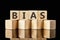 Bias text assembled from wooden cubes on a black background