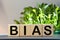 Bias - word from wooden blocks with letters, personal opinions prejudice bias concept, random letters around