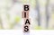 Bias - word from wooden blocks with letters, personal opinions prejudice bias concept, random letters around, white background