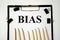 bias the word is written on a white piece of paper with pencils. text