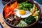 Bibimbap bowl with an array of colorful vegetables and a perfectly fried egg on top, ready to be mixed and savored