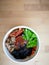 Bibimbap, traditional Korean dish in a take away box, rice with vegetables and beef.