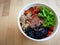 Bibimbap, traditional Korean dish in a take away box, rice with vegetables and beef.