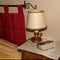 Bible on a bedside table under a lamp in a rustic style