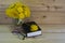 A Bible, glasses, a bunch of yellow dandelions on a wooden background. Warm tone.