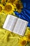 Bible Holy Writ and sunflowers on background of flag Ukraine