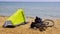 Bicycle and bicycle traveler`s tent on the seashore