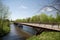 bicycle bridge over river, with cyclists pedaling along the path