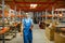 Bicycle factory, worker near the shelf, warehouse