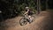 Bicycle freeride race in forest, female athlete fast rides by