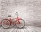 Bicycle in front of a grey brick wall.