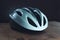 Bicycle helmet on wooden table, white plastic helmet on dark background, protection for cyclist,