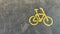 Bicycle icon in the right. Bicycle parking area with bicycle sign on top of the asphalt in the middle of the park