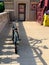 Bicycle leaning against bike rack as sun displays shadows of patterns on the sidewalk