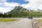 Bicycle with luggage stands in front of dramatic mountains at a