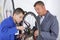 Bicycle mechanic and apprentice with wrench changing wheel