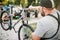 Bicycle mechanic in apron adjusts bike outdoor