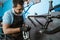 a bicycle mechanic attaches brake cables while assembling a bicycle frame