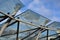 Bicycle parking shelter with glass roof with dotted print. Construction from bent gray tubes into an arc. tempered laminated glass