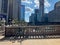 Bicycle and railing cast shadows onto the sidewalk of LaSalle Street by the riverwalk entrance near upper Wacker Dr