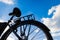 Bicycle, rear wheel and saddle against a blue sky with clouds