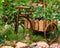 Bicycle-shaped flower stand on a flower bed in the garden.