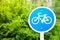 Bicycle sign on blue metal cycle isolated on green nature