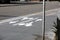 Bicycle sign on gray asphalt showing two cycles and direction arrows - special