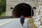 Bicycle tourist entering a tunnel, Norway