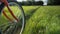 A bicycle wheel rides in a field on green grass